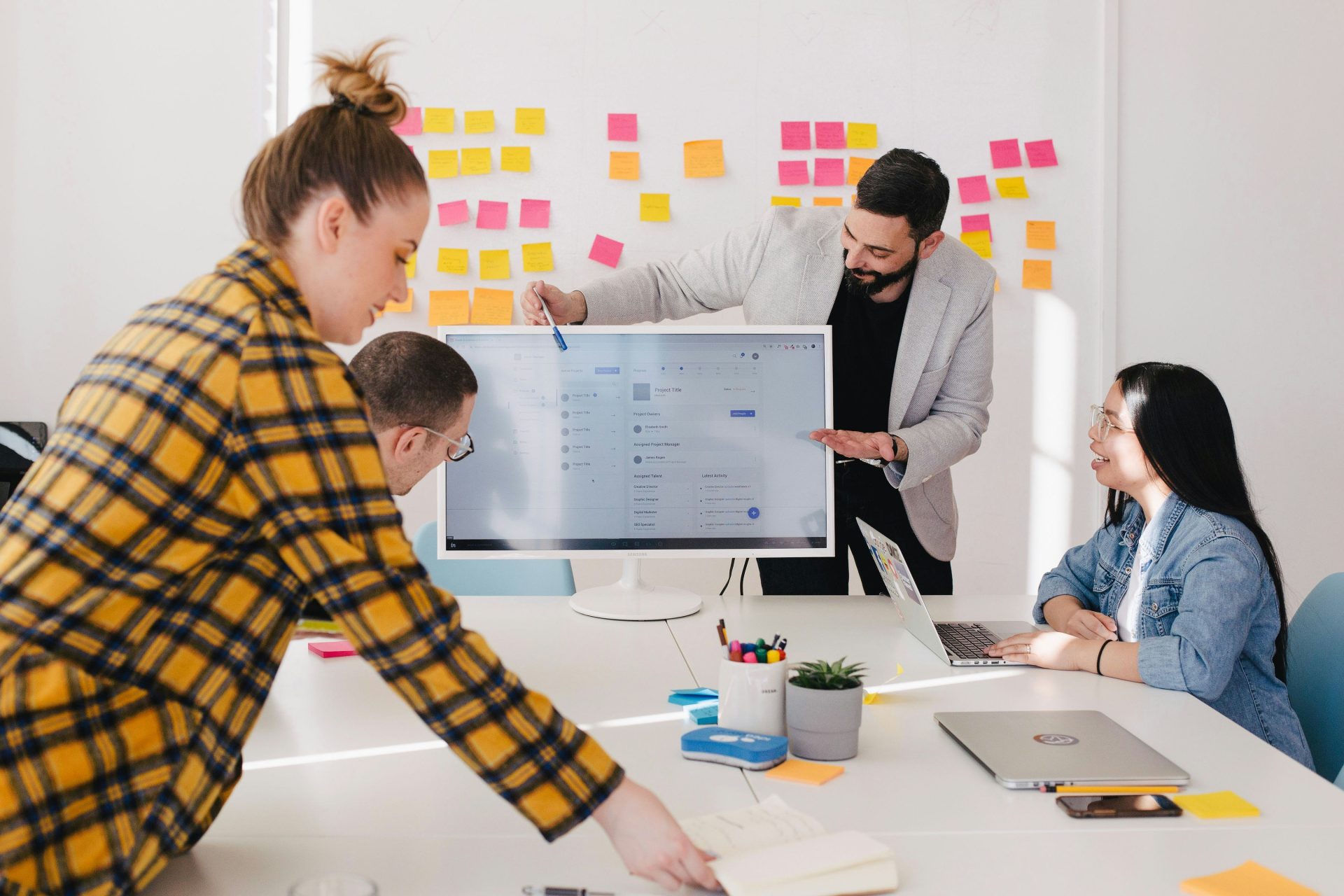 Team brainstorming with sticky notes and screen