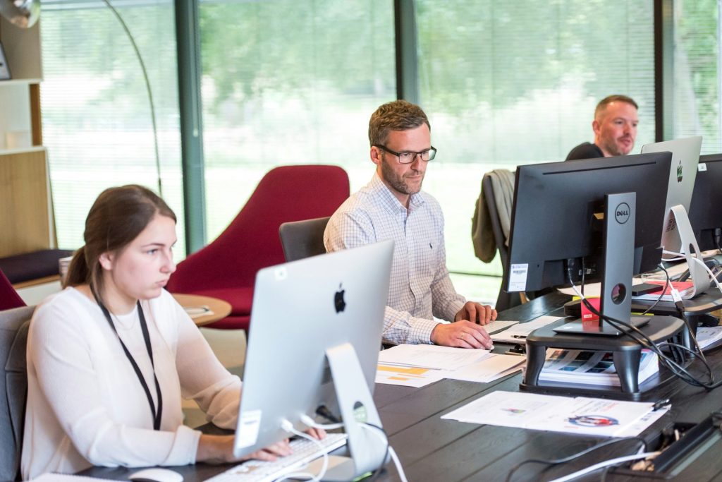 Office workers focused on computer tasks.