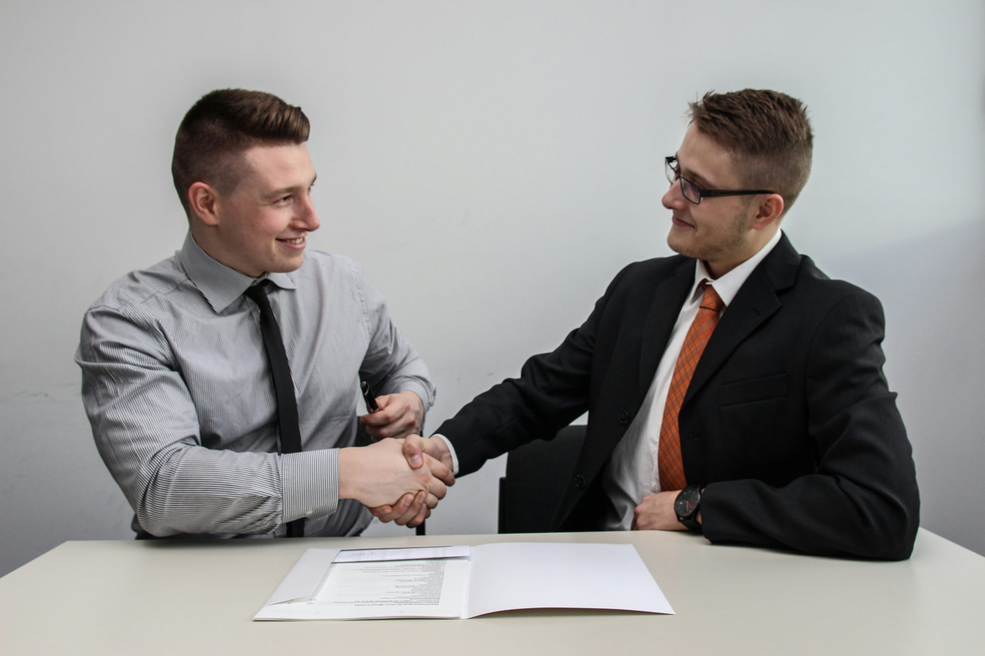 Two businessmen shaking hands happily